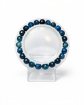 Amelia Jane Handmade Creations 7-inch faceted blue tiger's eye gemstone bead bracelet on a clear display stand.