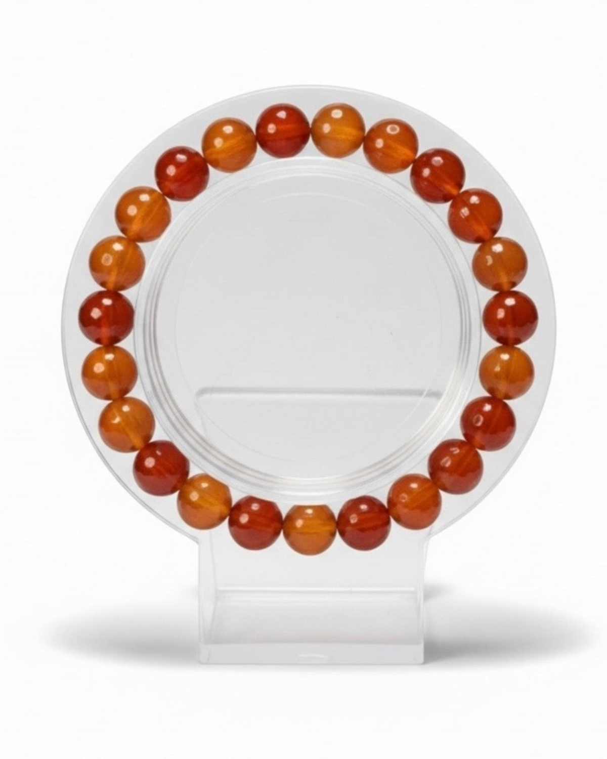 Amelia Jane Handmade Creations 7-inch faceted carnelian bead bracelet on a clear circular display stand.