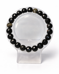 Amelia Jane Handmade Creations 7-inch faceted gold sheen obsidian beaded bracelet on a clear display stand.
