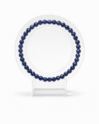 Amelia Jane Handmade Creations 7-inch faceted sodalite gemstone bead bracelet on a clear circular display stand