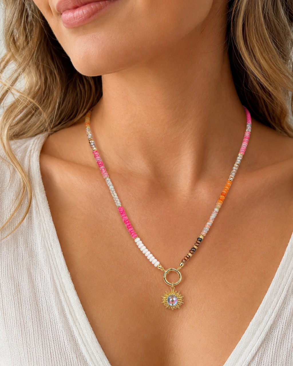 Amelia Jane Handmade Creations gemstone sunburst necklace with colorful beads and gold pendant on a woman