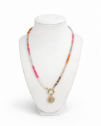 Amelia Jane Handmade Creations Summer Solstice necklace with multi-colored gemstone beads and a gold sunburst pendant.