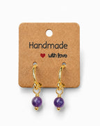 Amelia Jane Handmade Creations 15mm gold-filled huggie hoop earrings featuring dangling purple amethyst gemstones.