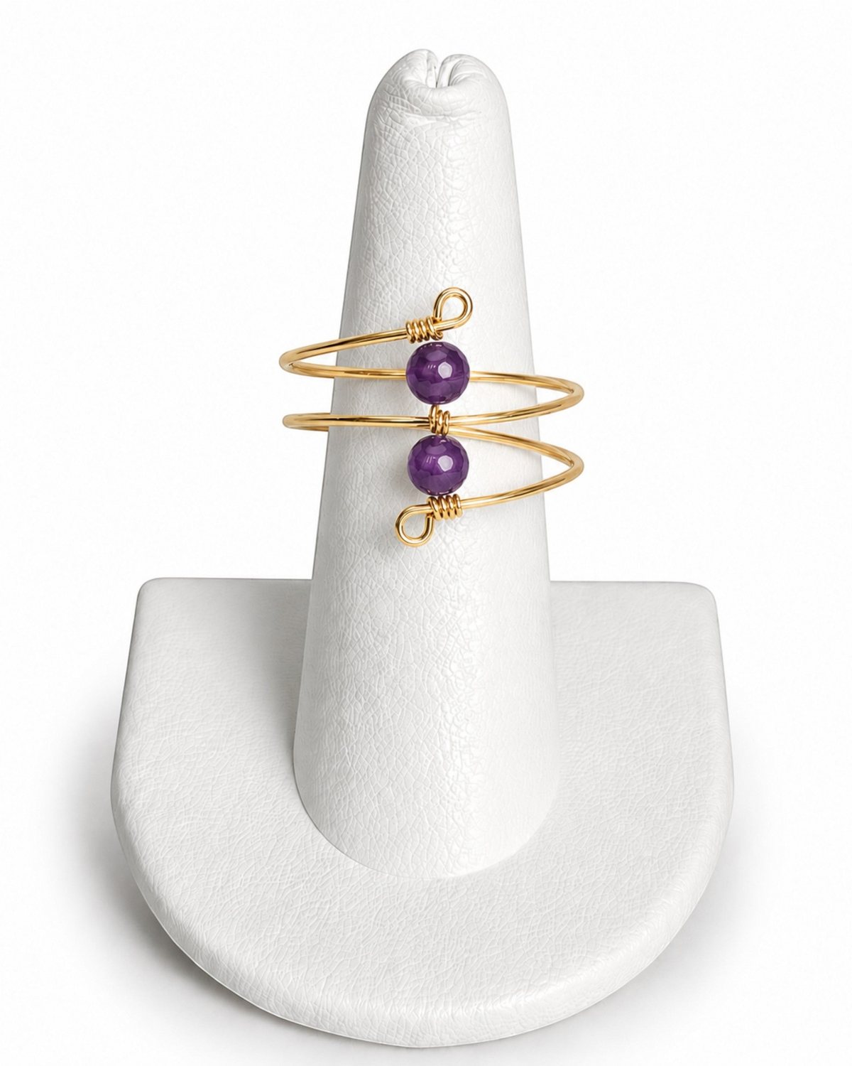 Amelia Jane Handmade Creations gold wire wrap ring featuring two purple faceted beads on a white display stand