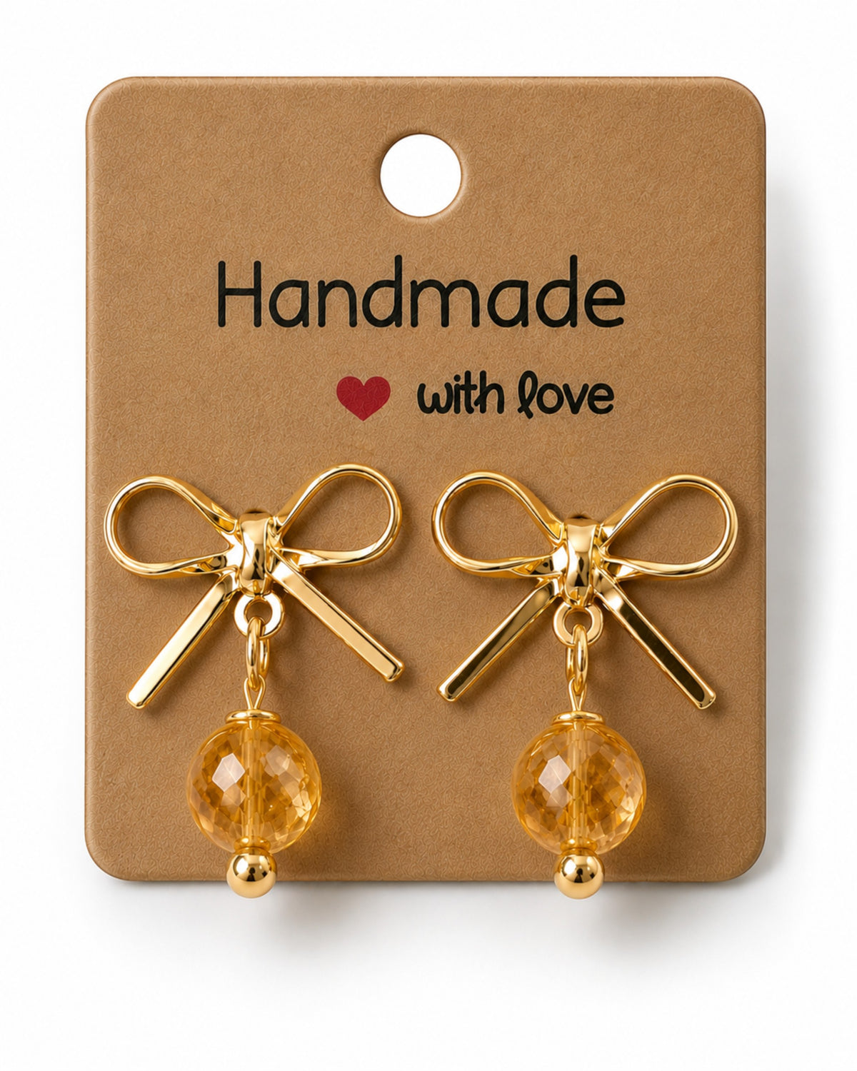 Amelia Jane Handmade Creations gold bow stud earrings with dangling faceted amber beads on a handmade display card.