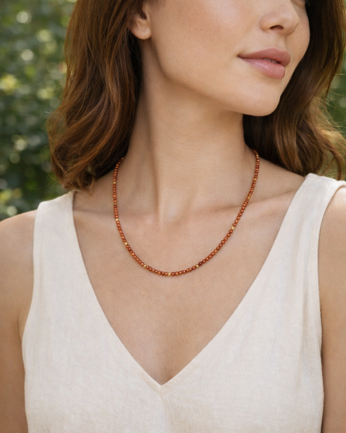 Amelia Jane Handmade Creations faceted goldstone and gold hematite beaded necklace worn by a woman