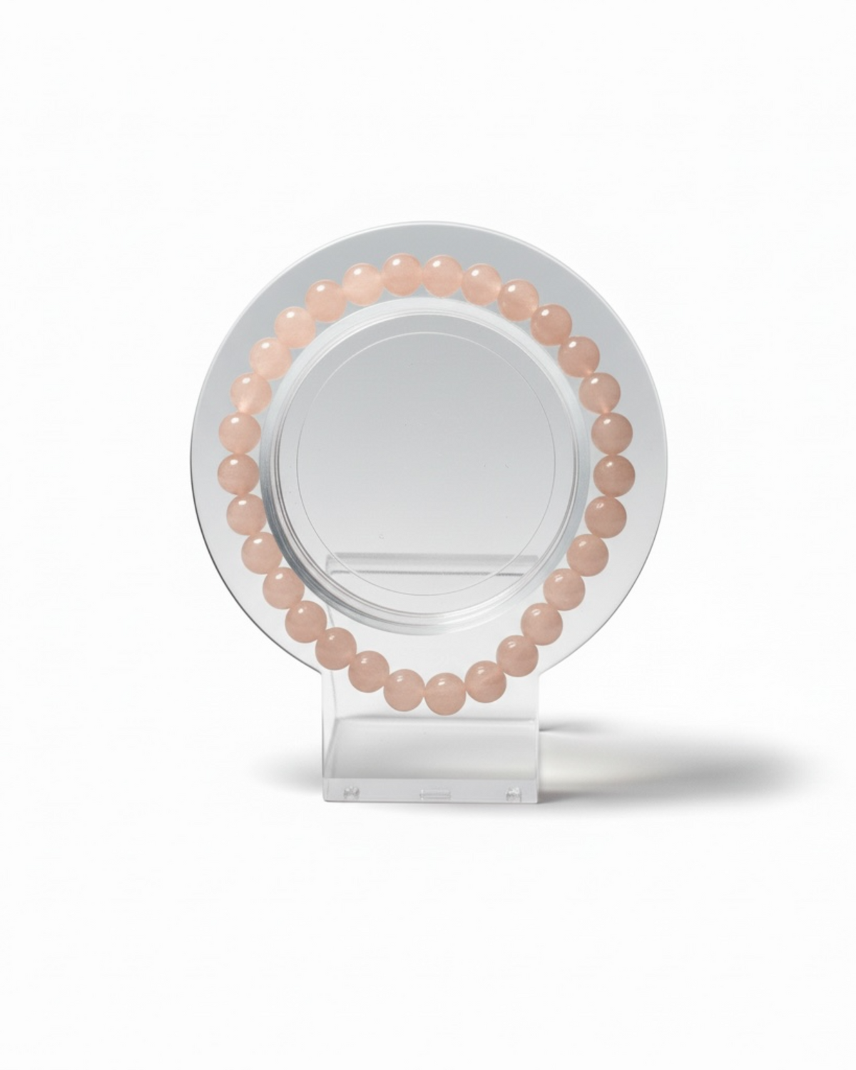 Amelia Jane Handmade Creations 7-inch peach moonstone beaded bracelet on a clear circular display stand