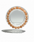 Amelia Jane Handmade Creations 7-inch peach moonstone beaded bracelet on a clear circular display stand.