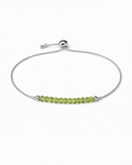 Amelia Jane Handmade Creations adjustable lariat bracelet featuring small green peridot beads on a silver chain.