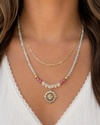 Amelia Jane Handmade Creations Pink Horizons necklace featuring aquamarine, pink tourmaline, and a gold wheel pendant.