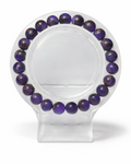 Amelia Jane Handmade Creations 7-inch purple chalcedony beaded bracelet on a clear circular display stand