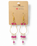 Amelia Jane Handmade Creations ruby chandelier earrings with gold wire and S925 posts on a display card.