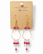 Amelia Jane Handmade Creations ruby chandelier earrings with gold wire and S925 posts on a display card.