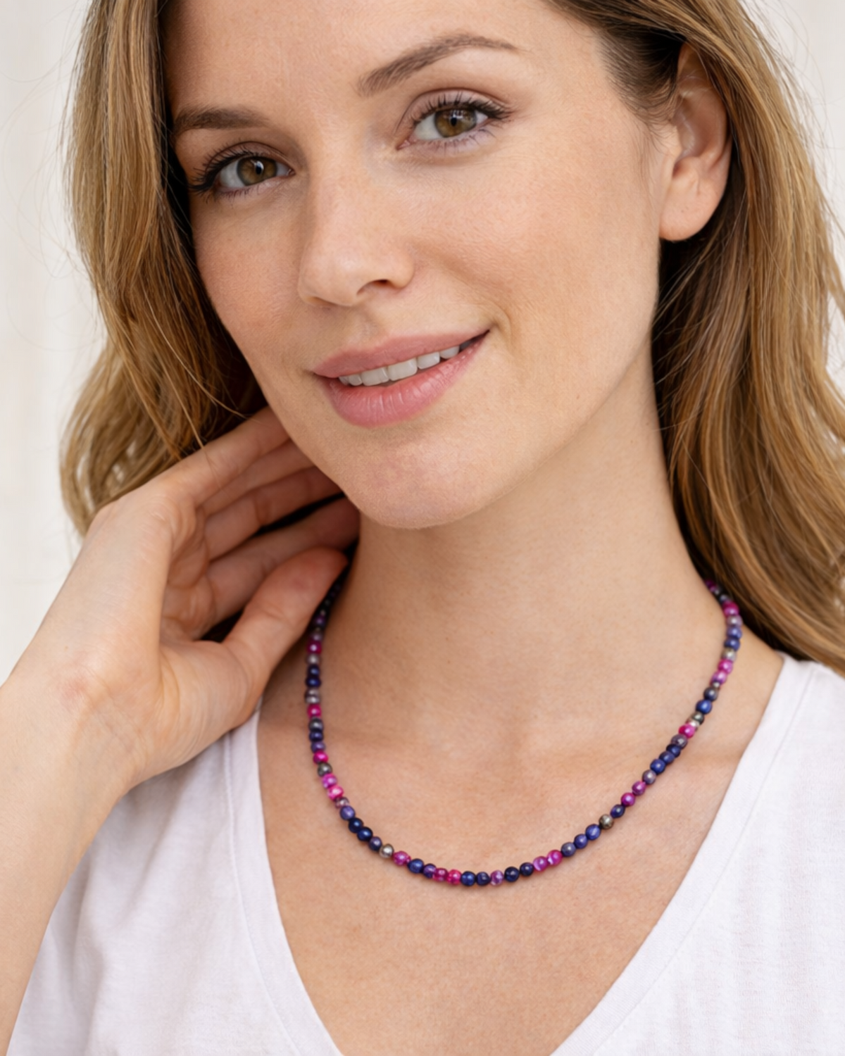 Amelia Jane Handmade Creations faceted ruby and blue sapphire beaded necklace worn by a woman in a white shirt