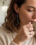 Amelia Jane Handmade Creations seraphinite dangle earrings with S925 silver posts worn by a woman holding a mug