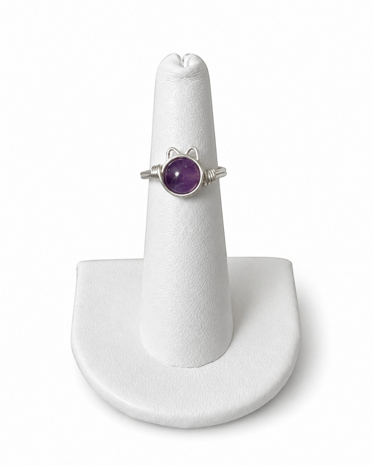 Amelia Jane Handmade Creations wire wrapped kitty ring with a round purple gemstone on a white display stand